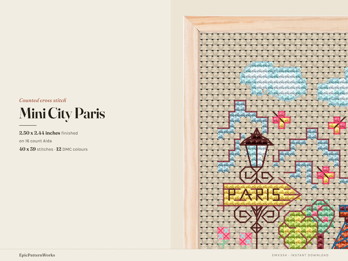 Cross stitch design of a small Paris cityscape showing a colorful Eiffel Tower, streetlamp with Paris sign, trees, clouds, and flowers on beige fabric.