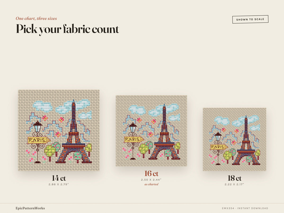 Cross stitch design of a small Paris cityscape showing a colorful Eiffel Tower, streetlamp with Paris sign, trees, clouds, and flowers on beige fabric.